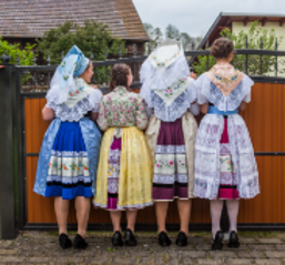 Trachtenträgerinnen Frauen in niedersorbischer Tracht schauen über einen Zaun