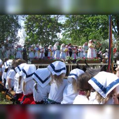 Kinder mit Kopftüchern sitzen vor einer Bühne in der Kita Spreewald. 2017 feierte die Kita Spreewald den 20. Geburtstag der Tanzgruppe Lutki.