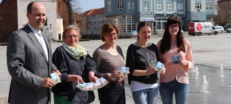 Bürgermeister Lars Kolan, Marlies Siegert von der evangelischen Kirchengemeinde, Bärbel Blume und Natalya Zimina von der Diakonie sowie Annabell Mai vom Übergangswohnheim (v.l.) präsentieren einen Pocket-Flyer für Neubürger.