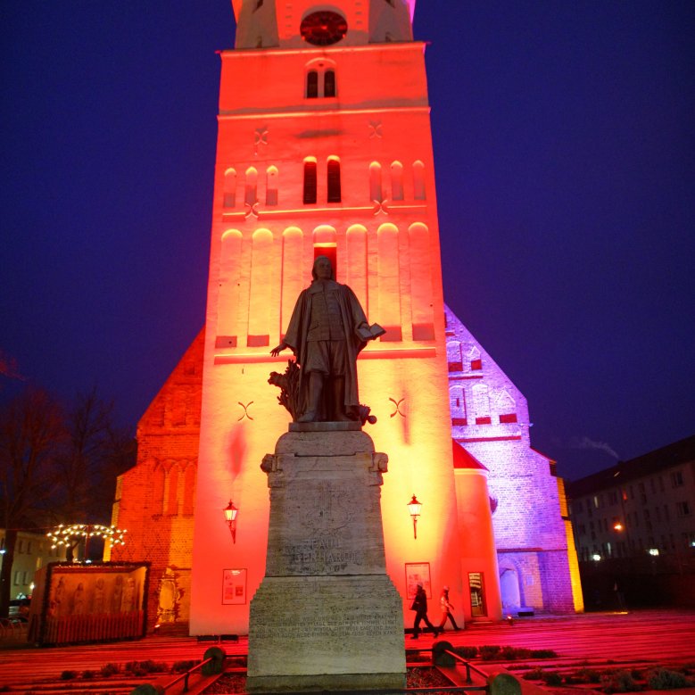 Das Paul-Gerhardt-Denkmal vor der Kirche bei Nacht.